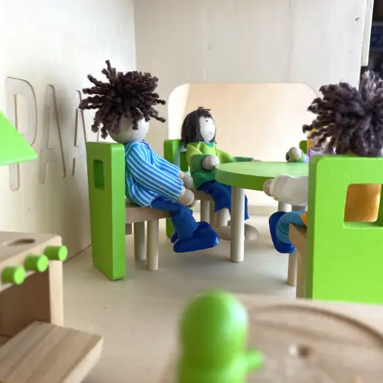 Diner Scène Een blik op een dinerend gezelschap poppenhuispoppetjes aan een eettafel in houten poppenhuis Benoë.